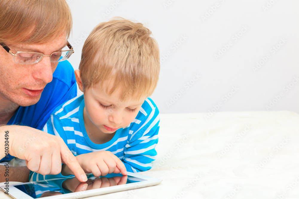 father and son looking at touch pad father and son looking at touch pad