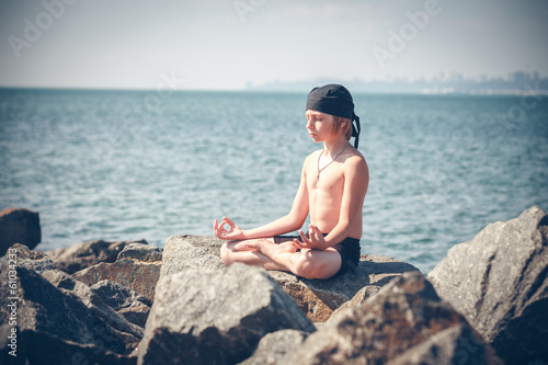 Young boy practising yoga on beach