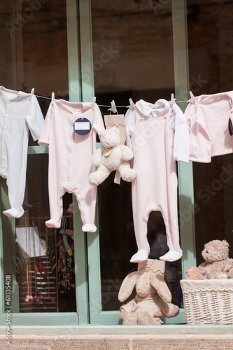 kleine baby strampler auf der wäscheleine im schaufenster photo