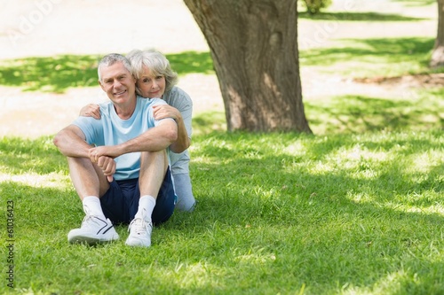 Mature couple sitting on grass at park