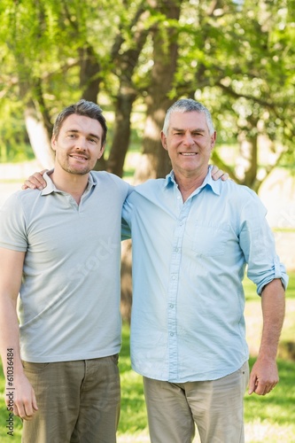 Smiling father with adult son at park