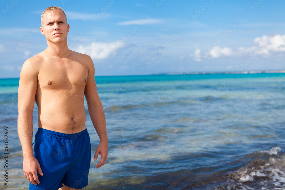 sportlicher junger mann in badehose am strand im urlaub sportlicher junger mann in badehose am strand im urlaub