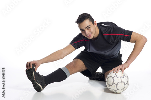 junger Fussballer hat Spass beim Dehnen