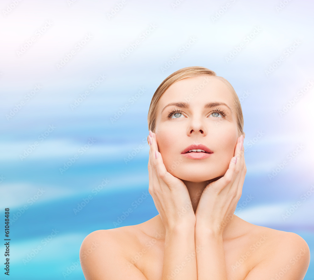 beautiful woman touching her face and looking up beautiful woman touching her face and looking up