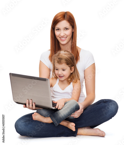 happy mother with adorable little girl and laptop