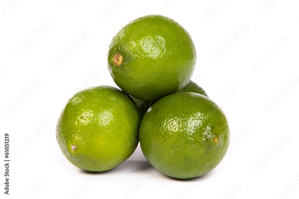 Group of whole limes and one half lime on white Group of whole limes and one half lime on white