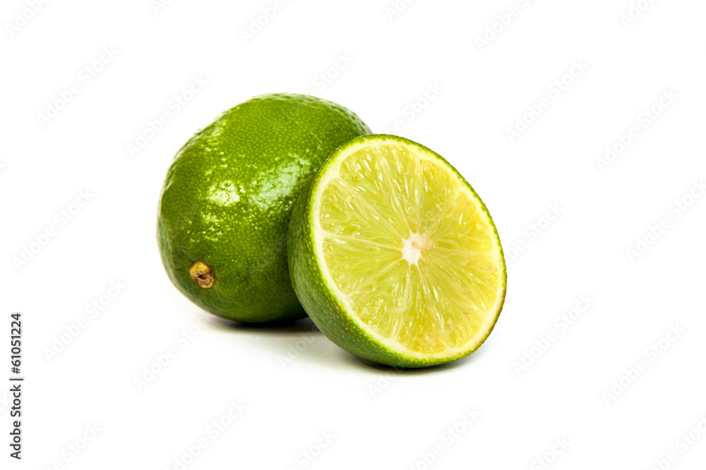 One whole lime and one half lime on white One whole lime and one half lime on white