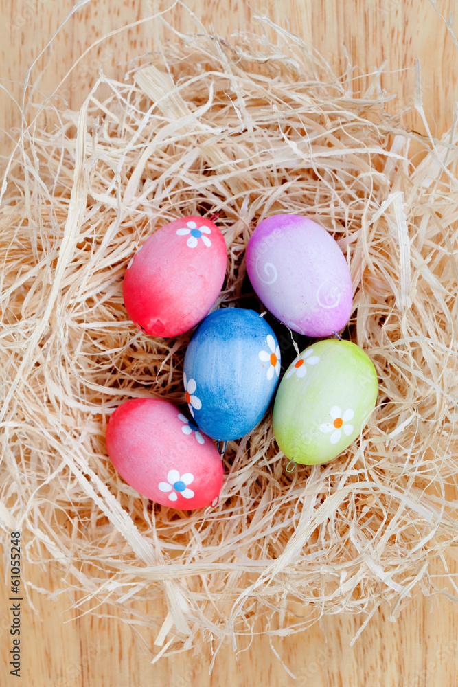 Easter eggs decorated with daisies on a nest of straw Easter eggs decorated with daisies on a nest of straw