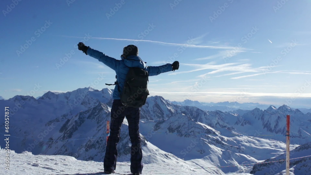 Woman standing on mountain peak with arms outstretched Woman standing on mountain peak with arms outstretched