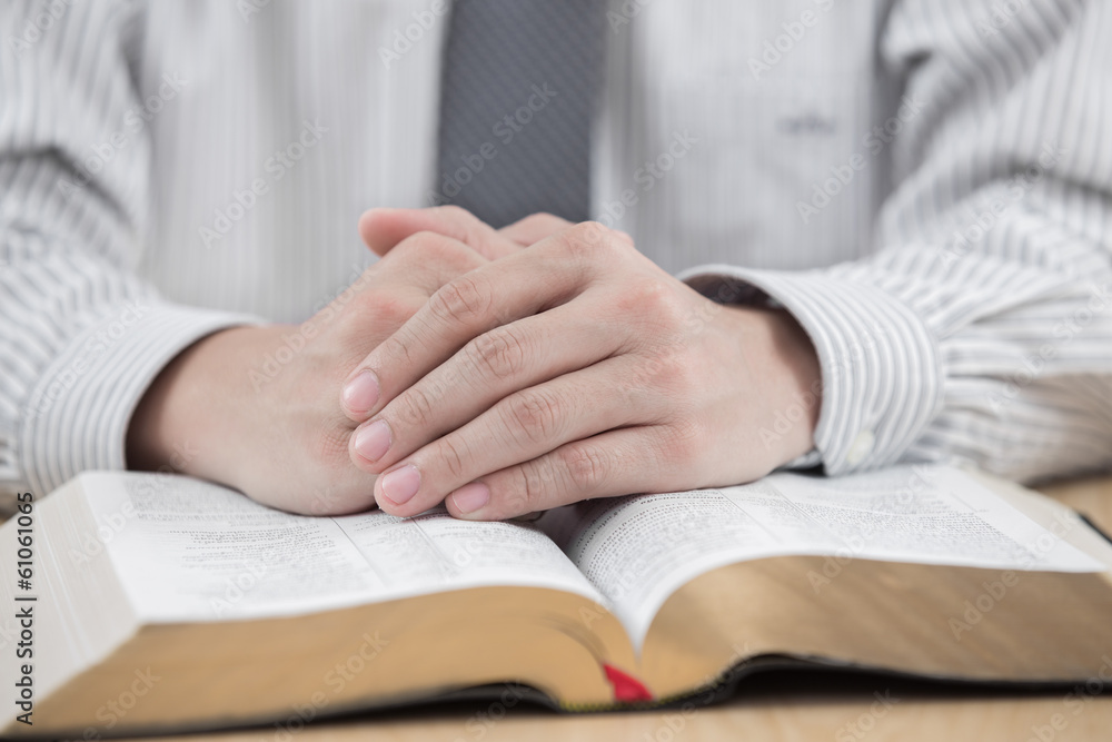 Obraz premium hands praying with bible