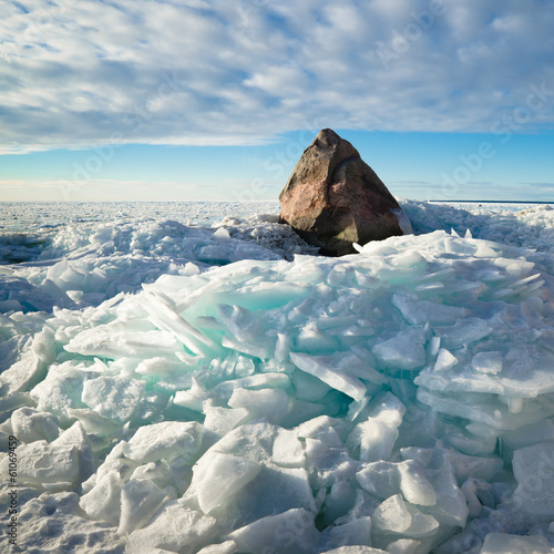 Big stone in the ice on the Baltic Sea coas
