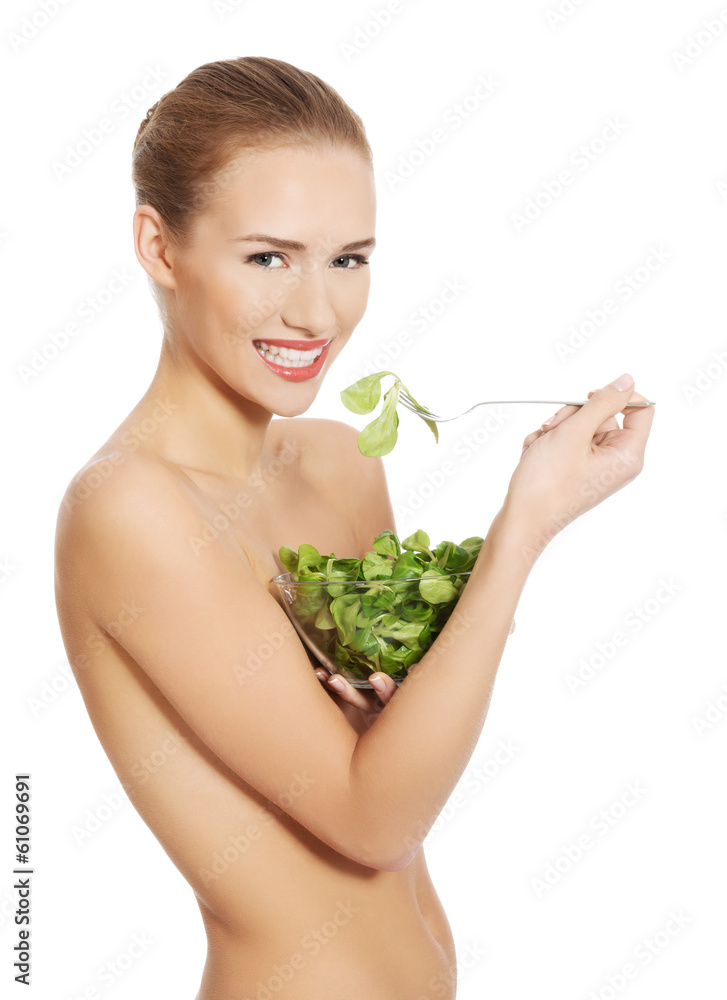 Beautiful caucasian topless woman eating lettuce from a bowl wit Beautiful caucasian topless woman eating lettuce from a bowl wit