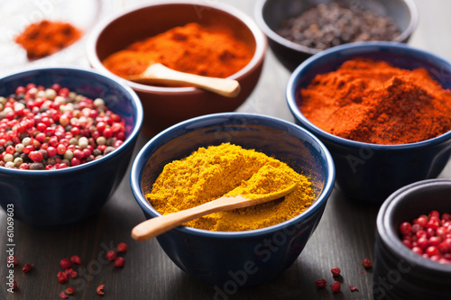 spices in bowls: curry, pink and black pepper, paprika powder