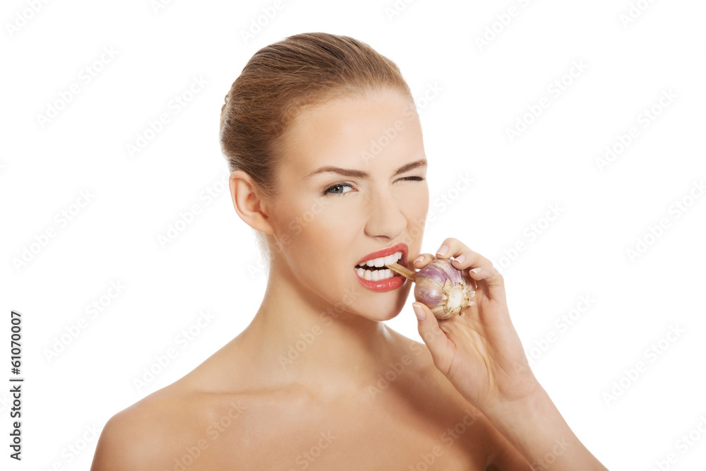 Beautiful caucasian topless woman with raw garlic in mouth. Beautiful caucasian topless woman with raw garlic in mouth.