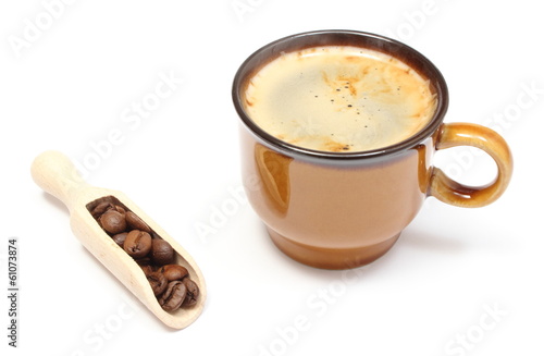 Coffee grains on wooden spoon and cup of beverage