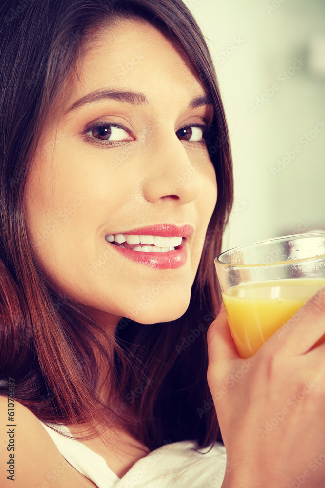 Woman in bed drinking orange juice