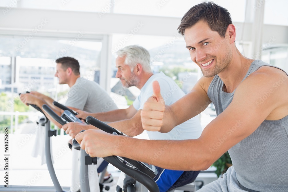 Man on exercise bike gesturing thumbs up Man on exercise bike gesturing thumbs up