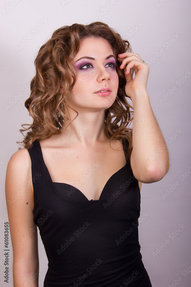 Fototapeta premium Portrait of a beautiful young girl with brown curly hair