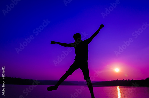 silhouette jumping man on the lakeside