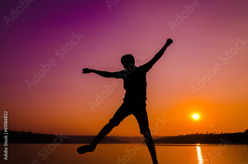 Fototapeta Naklejka Na Ścianę i Meble -  silhouette jumping man on the lakeside