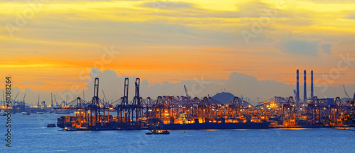 Silhouette of several cranes in a harbor, shot during sunset.
