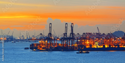 Silhouette of several cranes in a harbor, shot during sunset.