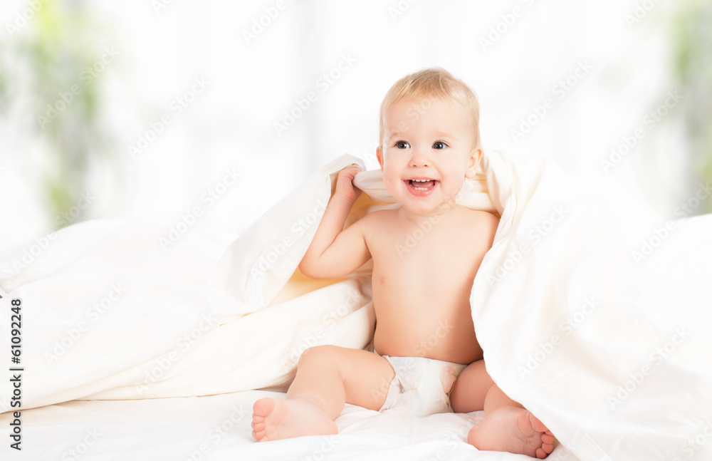 happy baby under a blanket laughing