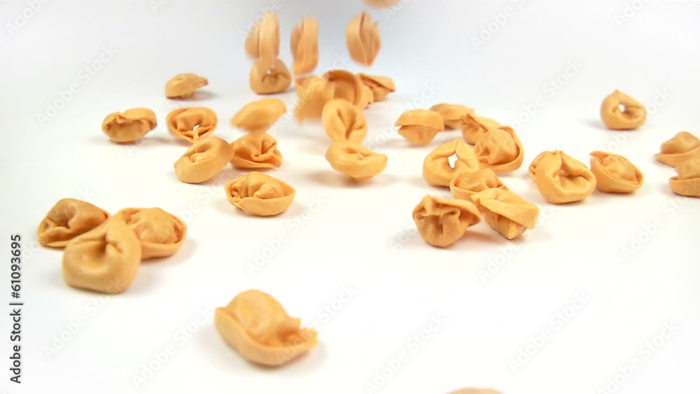 red tortelli pasta falling on white background in slow motion red tortelli pasta falling on white background in slow motion