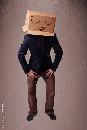 Young man gesturing with a cardboard box on his head with smiley