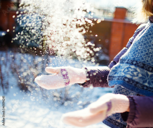 Women playing with snow in sunny winter day  close up photo
