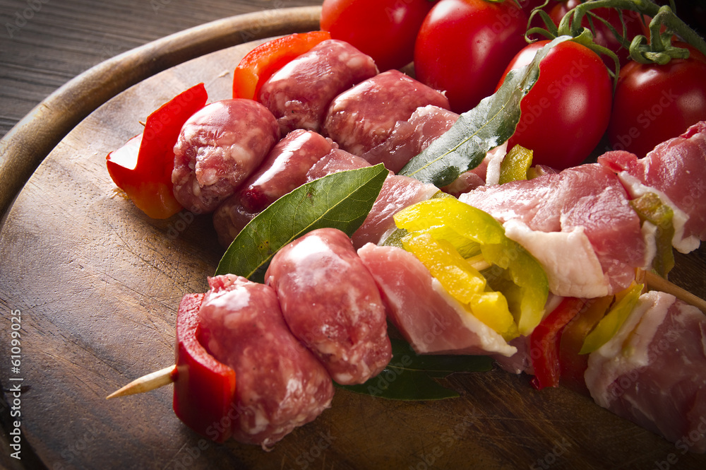 skewers of chicken and sausage on the chopping board