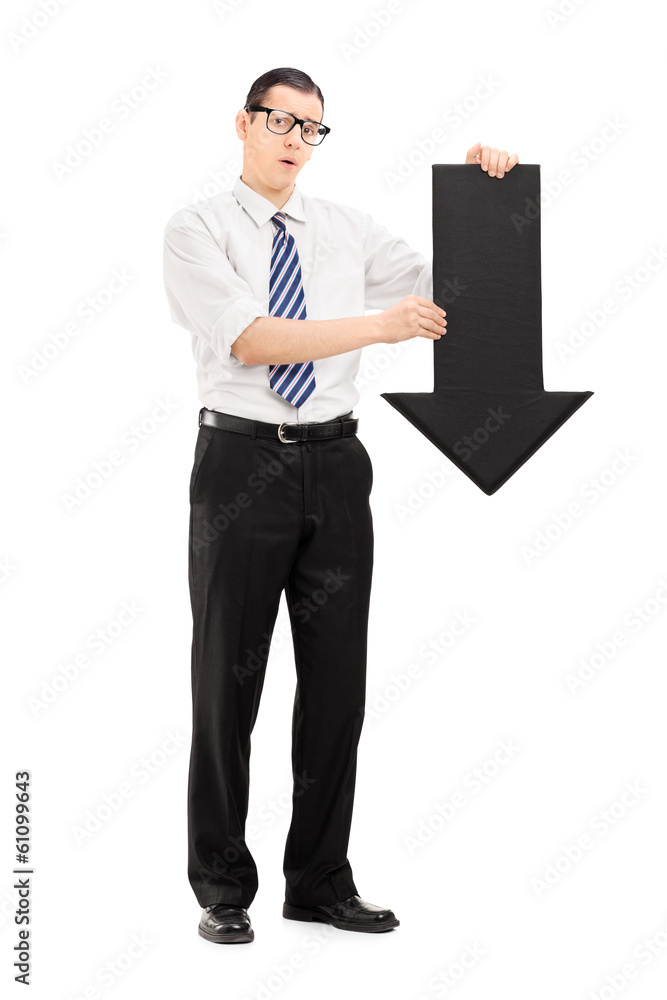 Sad man holding a big black arrow pointing down Sad man holding a big black arrow pointing down