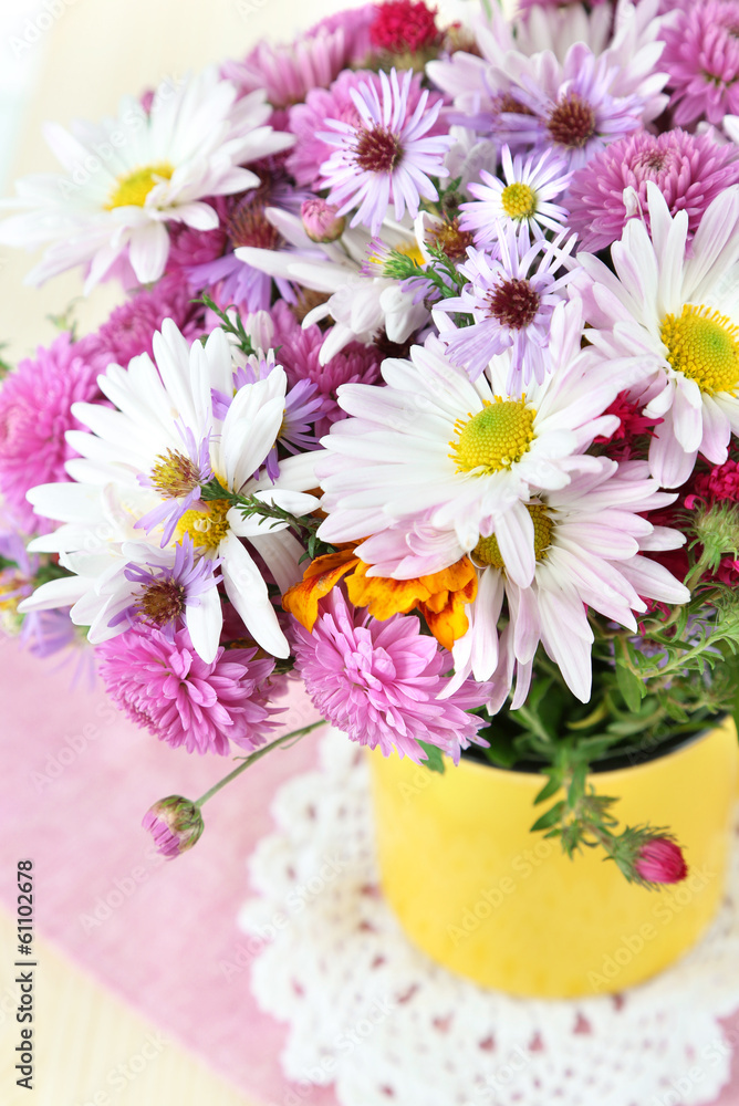 Wildflowers in mug on napkin on wooden table Wildflowers in mug on napkin on wooden table