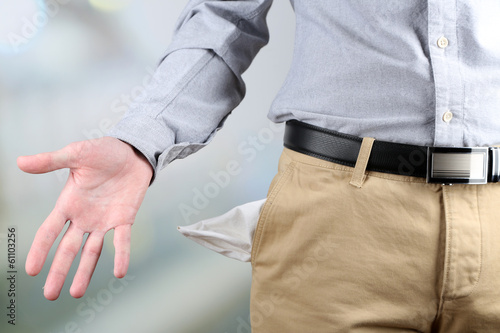 Man showing his empty pocket on bright background