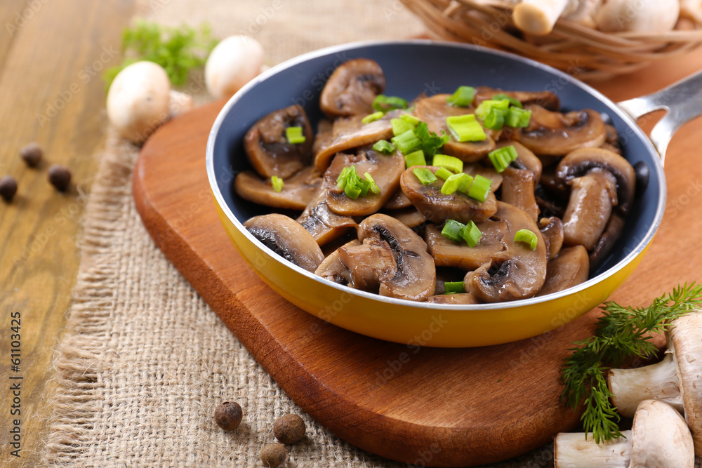 Delicious fried mushrooms in pan on table close-up