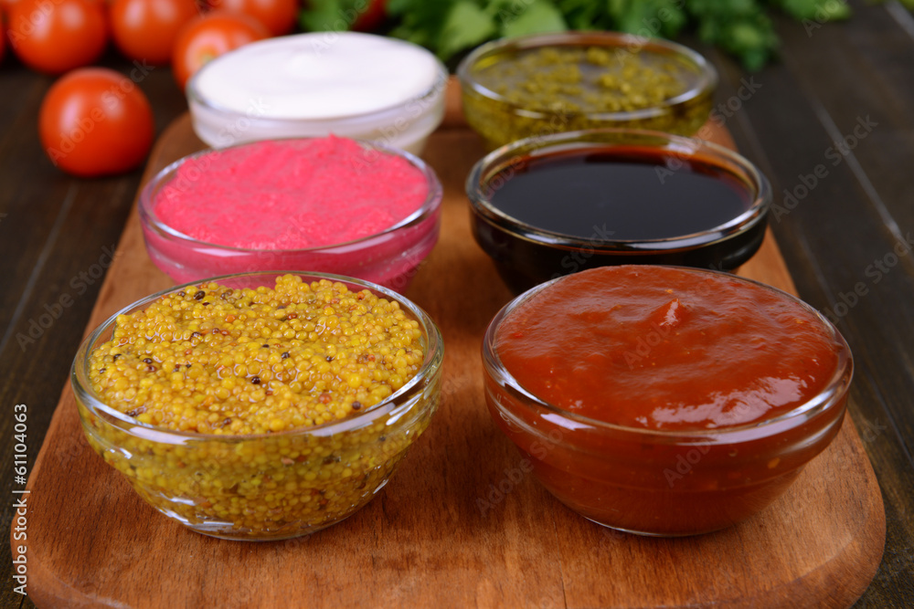 Various sauces on chopping board on table close-up Various sauces on chopping board on table close-up