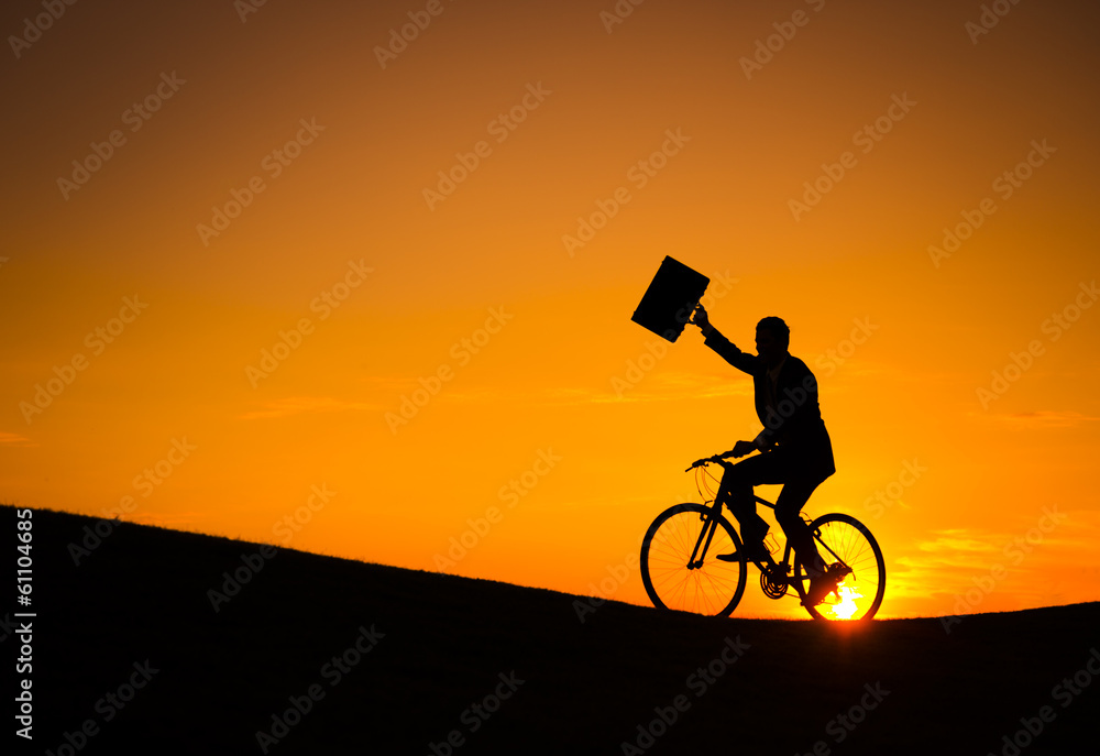 Obraz premium Businessman on a Bike at Sunset