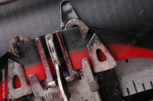 Macro close up of a typewriter key striking the ink ribbon