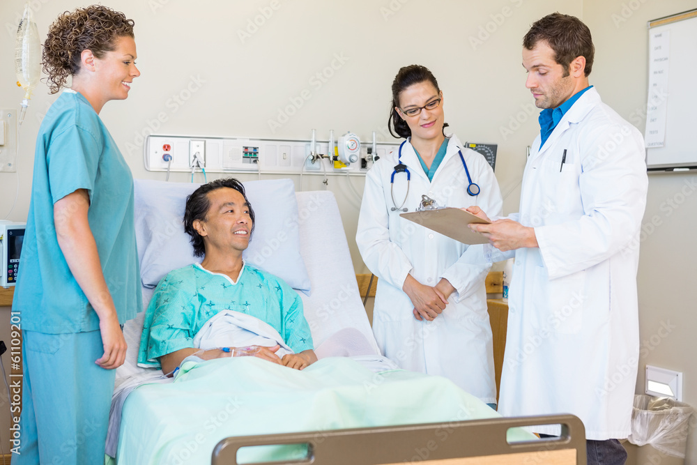 Obraz premium Doctors Discussing Notes While Nurse And Patient Looking At Them