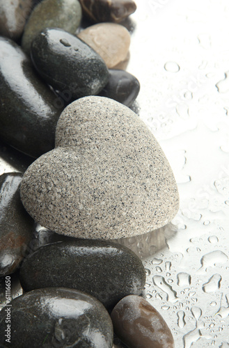 Grey stone in shape of heart  on light background