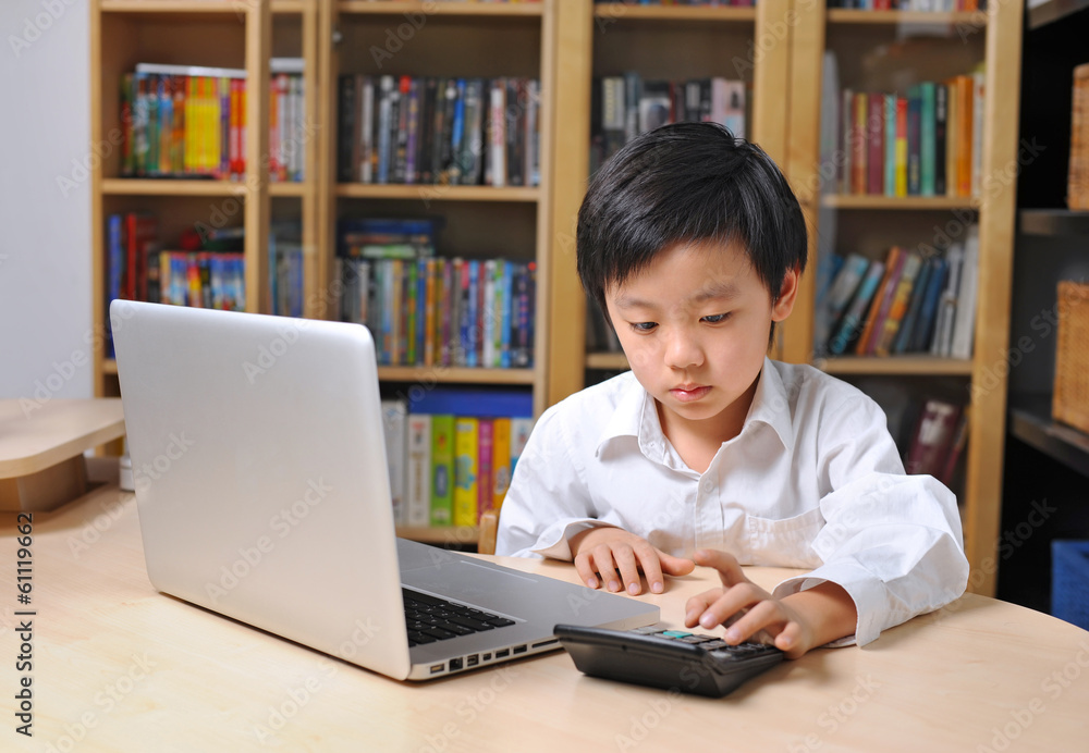 School boy in front of computer and making calculations School boy in front of computer and making calculations