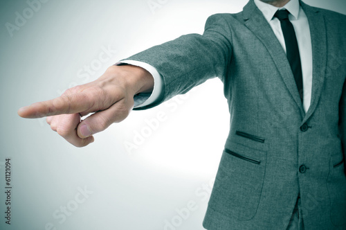 Foto man in suit pointing with the finger the way out