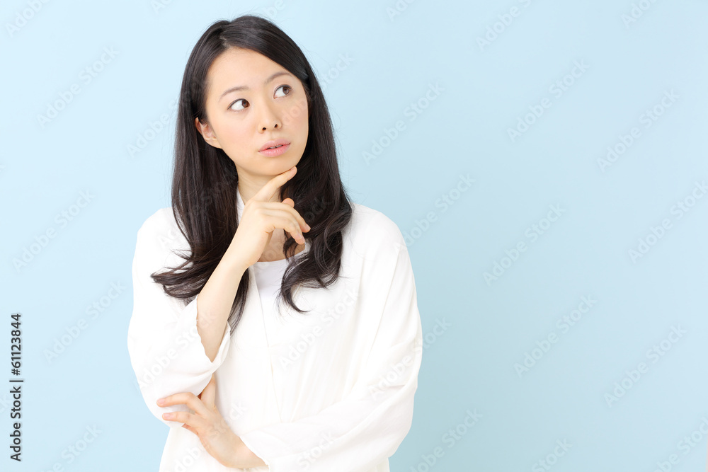 悩む女性・ブルーバック 悩む女性・ブルーバック