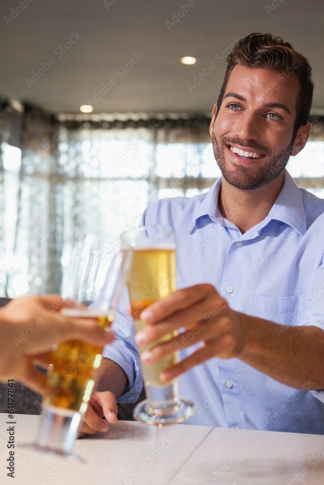 Happy businessman clinking glass of beer with bartender Happy businessman clinking glass of beer with bartender