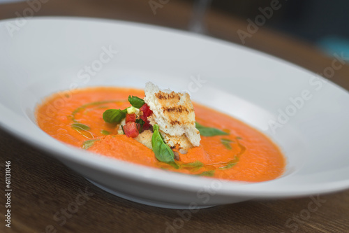 Image of tasty pumpkin soup with crouton and basil served in res