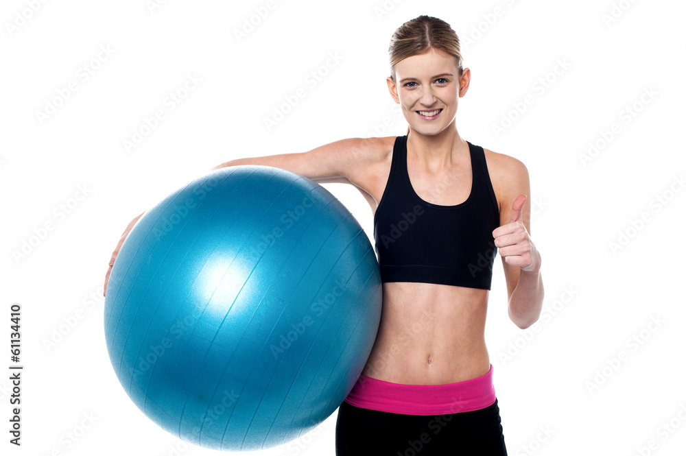 Fitness girl with aerobic ball showing thumbs sign Fitness girl with aerobic ball showing thumbs sign