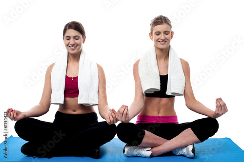 Two young girls doing yoga at gym