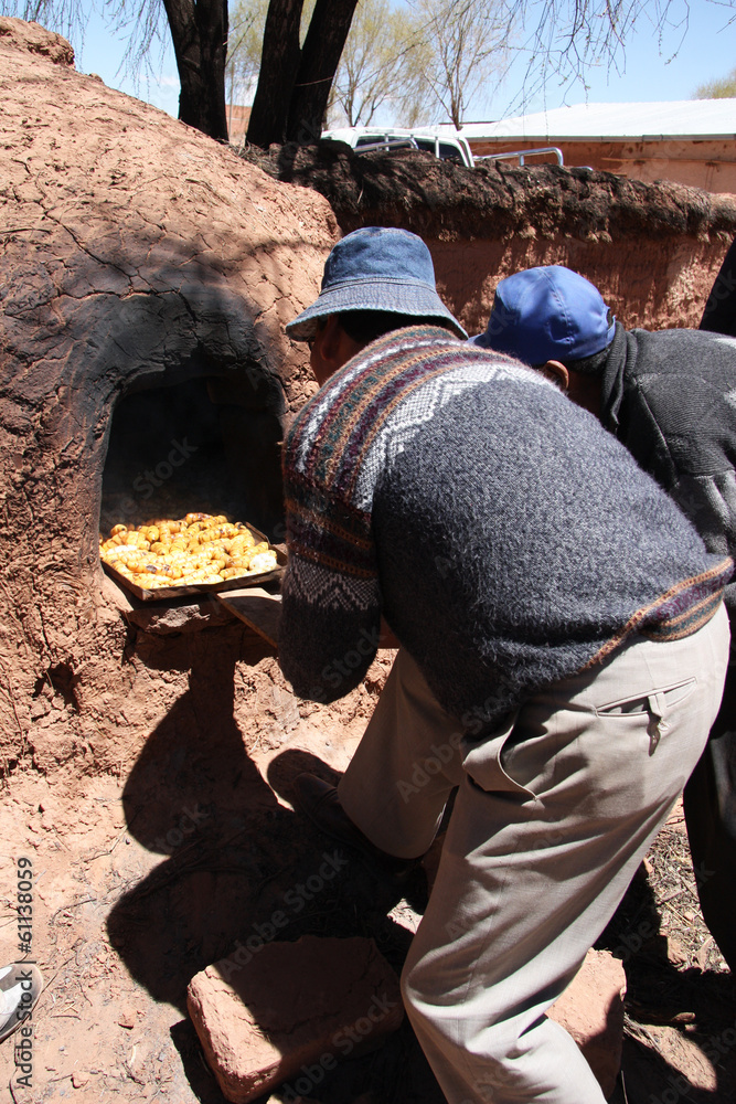 Indian men cook in Clay Oven in Bolivia, South America