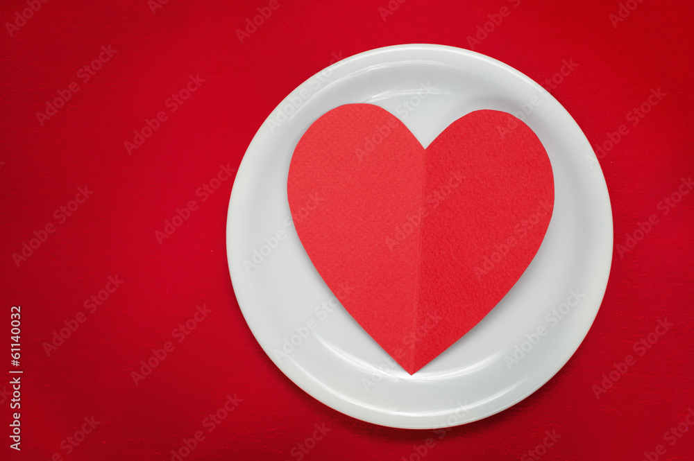 Red velentines heart on plate on red background Red velentines heart on plate on red background