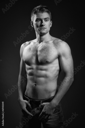 Strong athletic man on dark background
